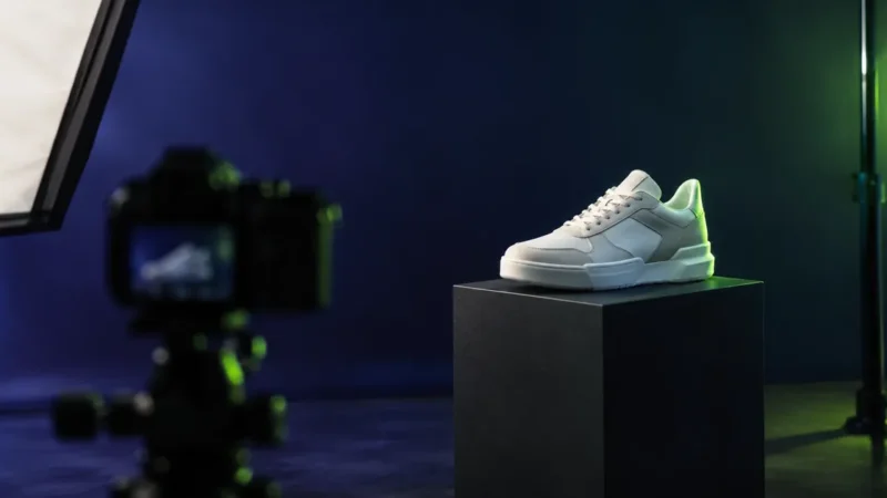 White sneaker on a lit pedestal in a product photo studio for ecommerce product page SEO